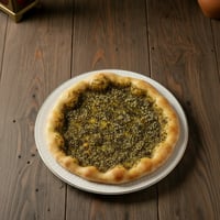 مقنوشه زعتر على طاوله في مطعم بيت المحاشي على طاوله خشبيه
