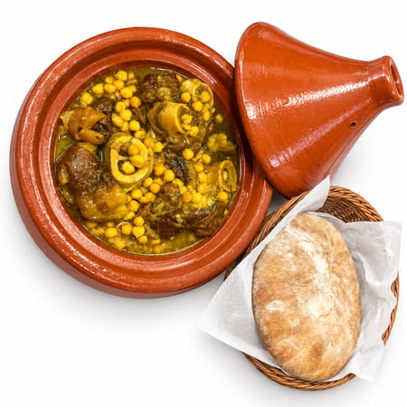 طاجين كوارع مغربي بالحمص مع خبز مغربي وغطاء فخاري على خلفية بيضاء