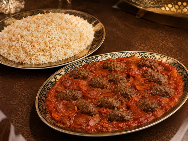 وجبة كباب هندي سوري بقطع اللحم المطهية مع الطماطم، تقدم في طبق فاخر مع طبق منفصل من الأرز بالشعيرية من دون مكسرات.